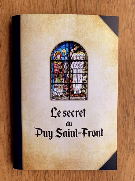 Livret de l'enquête "Le Secret du Puy Saint-Front" posé sur une table en bois
