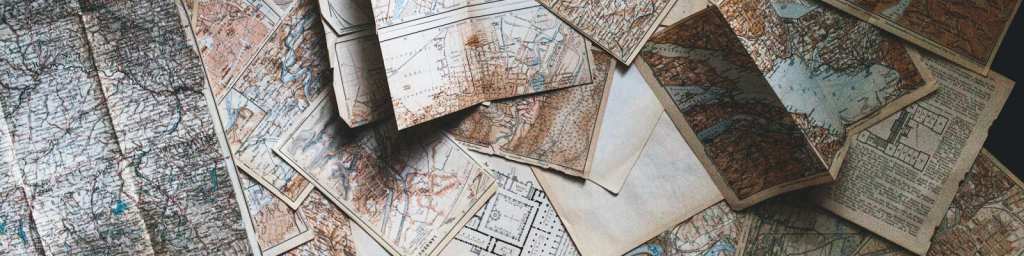 De nombreuses cartes et plans anciens étalés au sol